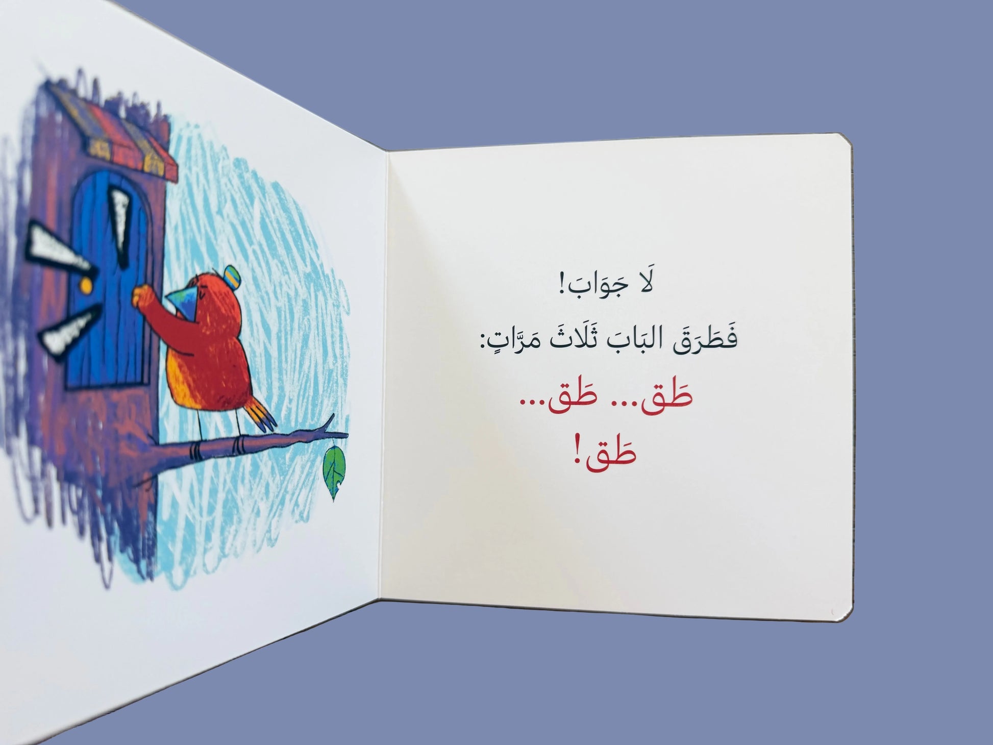 Open book with a colorful illustration of a child knocking on a door and Arabic text on a wooden surface.
